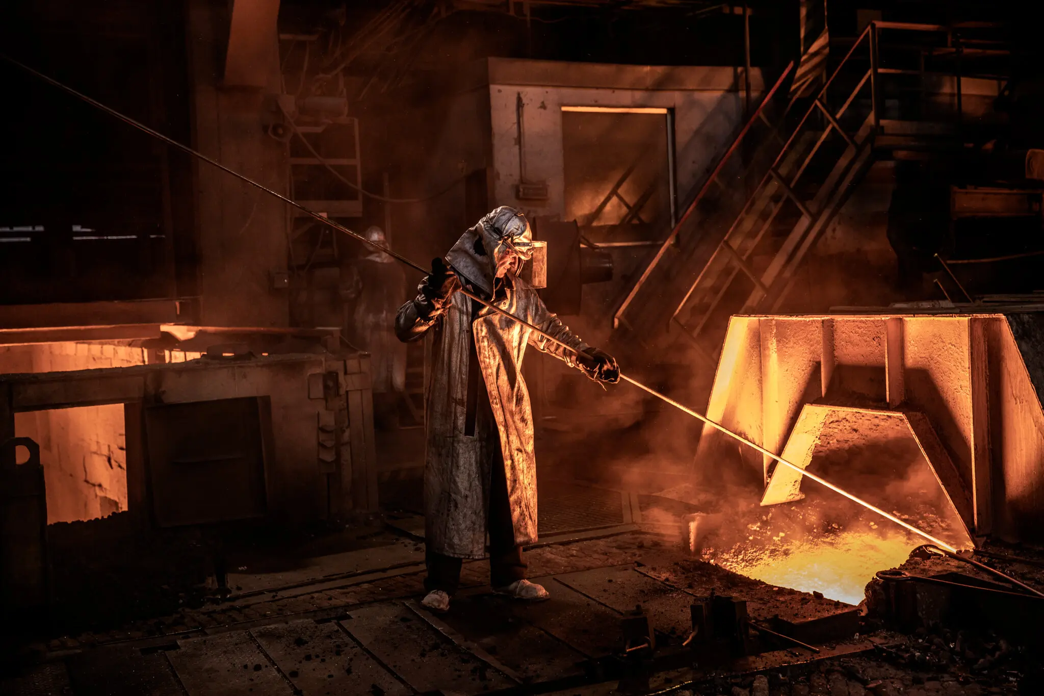 Робітник за допомогою зонда спрямовує розплавлений чавун із доменної печі металургійного заводу «Запоріжсталь».